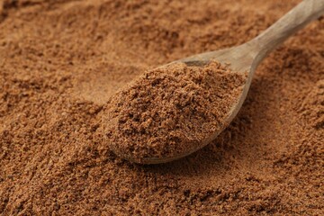 Superfood supplement. Nutmeg powder and spoon, closeup