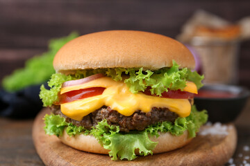 Tasty cheeseburger with sauce on table, closeup