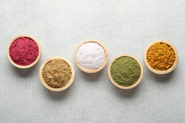 Different superfood powders on light grey table, flat lay