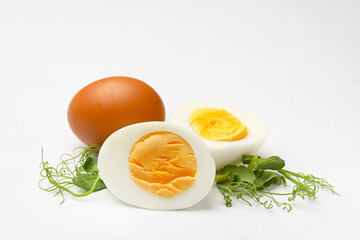 Boiled eggs and microgreens on white background