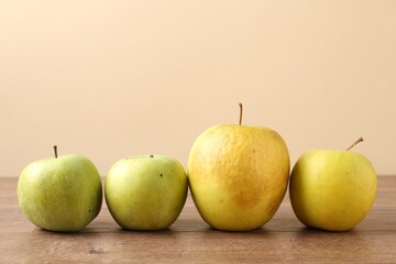 Many damaged green apples on wooden table. Space for text