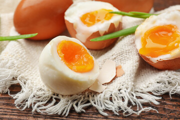 Soft boiled eggs with green onions on wooden table, closeup