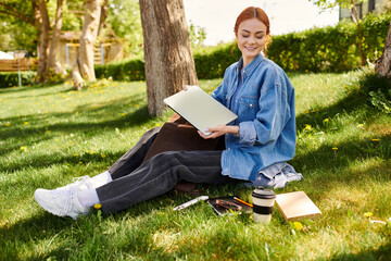 Fototapeta premium Joyful creative moment in nature with a red haired woman enjoying her artistic pursuits
