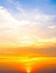Fototapeta premium A vibrant sunset paints the sky in hues of orange, pink, and purple, as the sun dips below the horizon, casting a warm glow over the tranquil landscape.