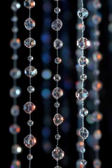 Close-up of hanging crystal beads reflecting colorful light with a blurred dark background, creating a sparkling and elegant atmosphere