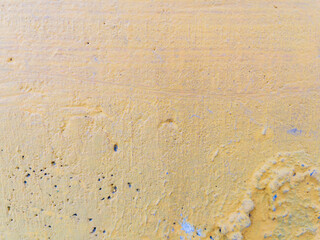 Closeup texture of yellow painted weathered concrete wall