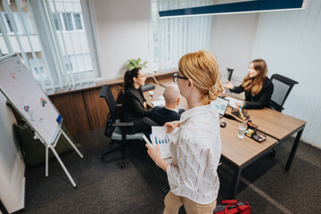 Collaborative team in a meeting room discussing work tasks with charts and laptops, emphasizing business cooperation and team interaction in a professional setting
