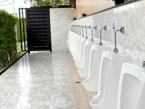 The bathroom has a clean white ceramic urinal for men.
