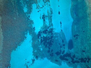 Vue aérienne des fonds marins dans une eau bleu avec des nuances de bleu