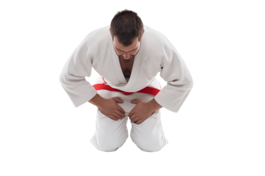 Judoka in white gi performs formal bow while kneeling isolated on white background