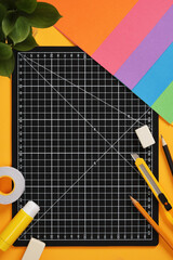 Top view of the paper crafts work table. Craft knife, pencil, eraser, cutting mat, paper. Place for your text.