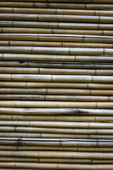 Close-up view of horizontally stacked bamboo poles showing natural textures and color variations
