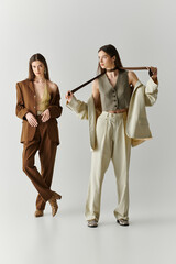 Stylish twin sisters showcasing modern fashion in a chic indoor setting