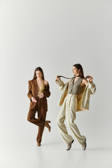 Stylish twin sisters showcasing their unique fashion in a modern studio setting