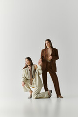 Stylish twin sisters posing elegantly in fashionable outfits while showcasing their bond