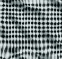 Close-up of fabric with a black and white houndstooth pattern showing texture and soft folds