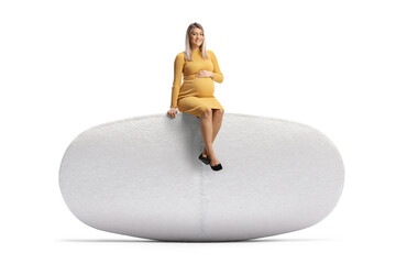 Pregnant woman sitting on a big pill