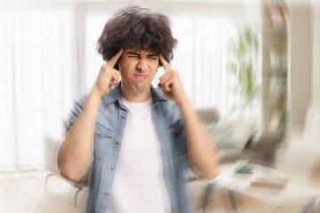 Young man at home suffering from headache