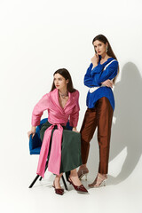 Twin sisters exude charm and style with their coordinated outfits in a chic, minimal environment