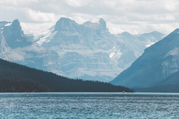 peaceful landscape view of maligne lake on a summer clpudy day in pale pastel colours
