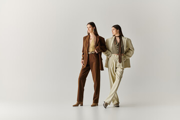 Stylish twin sisters express their unique fashion sense in a chic indoor setting