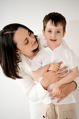 a mother and child hug and play, having fun on a white isolated background, a mother and a small child, a mother and son.