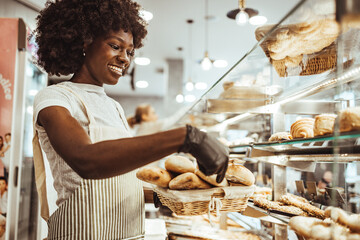 Smiling Worker Serving Fresh Bread in a Modern Bakery Shop
