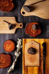 Wood log tree slices and cutting boards on black chalkboard. Flat lay. Top view