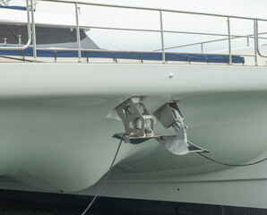 Two different anchors, plow type and another spade type mounted on the bow of modern sailing...