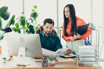 Business professionals collaborating on a project in a modern office workspace, focused on teamwork