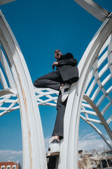 A businessman wearing a suit creatively posing outdoors on a geometric structure