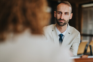 Focused business person in a formal meeting setting, attentively engaged in a discussion. Ideal for...