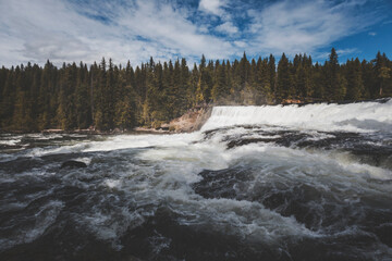 summer clear day in Wells Gray Provincial Park. scenic views of wide and high waterfalls in a outdoor andventurous trip. splashing water, intense green and high contrast light all around