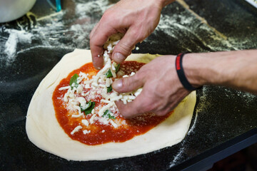 Adding cheese to homemade pizza