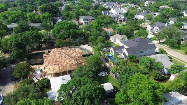 Timber framing of two-story wooden mansion houses, large structural posts, beams to create strong, durable framework new construction home in wealthy neighborhood Walnut Hill in Dallas, flyover