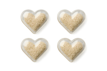Fototapeta premium Four heart-shaped containers filled with a light-colored substance, likely a type of sugar or sweetener. Concept Heart-Shaped Containers, Sweet Substance, Sugar Alternatives, Creative Packaging