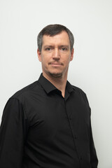 Adult man with mustache in black shirt on white background