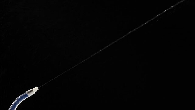 Portable oral irrigator on black background, close up. Dental teeth whitening, flosser bucal tooth cleaner, waterpulse, water thread for teeth. Stream of water from an irrigator nozzle