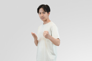 young man expressing determination with confident gesture in casual white shirt