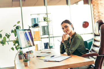Confident businesswoman in an elegant office environment working at her computer and planning her...
