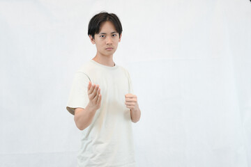 young man expressing determination with confident gesture in casual white shirt