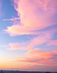 Fototapeta premium A breathtaking sunset paints the sky in soft shades of pink, blending with hints of orange and purple, creating a serene and dreamy atmosphere.