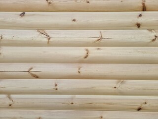 Exterior finishing of the house with wood. Beautiful wooden wall. Texture of unpainted logs. Natural wood pattern