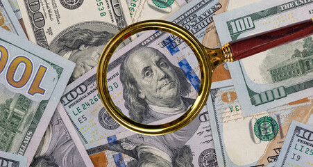 magnifier glass with US USD paper dollar bills