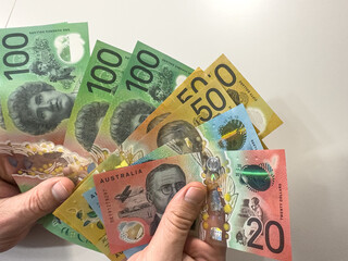 Businessman holding Australian dollar money AUD, close up. Financial, investment concepts