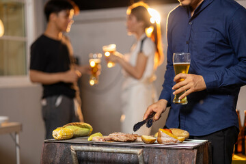 A vibrant summer gathering comes to life as men and women celebrate around a sizzling barbecue. With flames dancing on the grill and fresh vegetables alongside savory meats, the group shares drinks, l