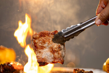 Juicy, tender steak sizzles over open flames on a rustic barbecue grill, with herbs and smoke enhancing the rich aroma of outdoor cooking.
