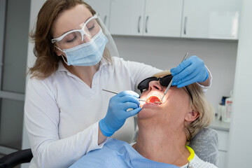 Senior female client having repairing tooth at dentist's office. Concept of ready for teeth cure