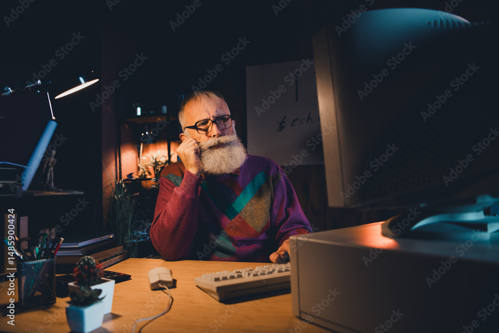 Poster elderly programmer working late at home office desk, wearing colorful sweater, focused on computer c