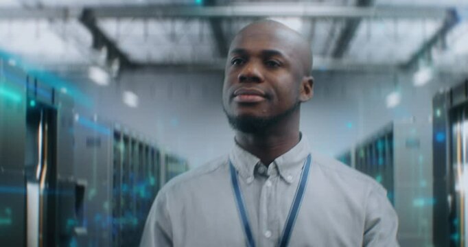 African American Administrator Walking in Futuristic Big Data Center with VFX, Smiling, Looking at Camera. Animated Diagrams of Internet Traffic on Servers. Information Technology and Digitalization.